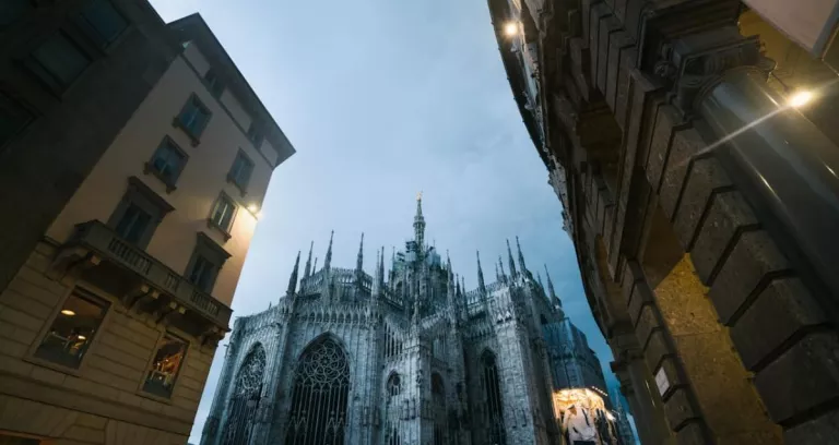Milan Cathedral And City Street In Evening