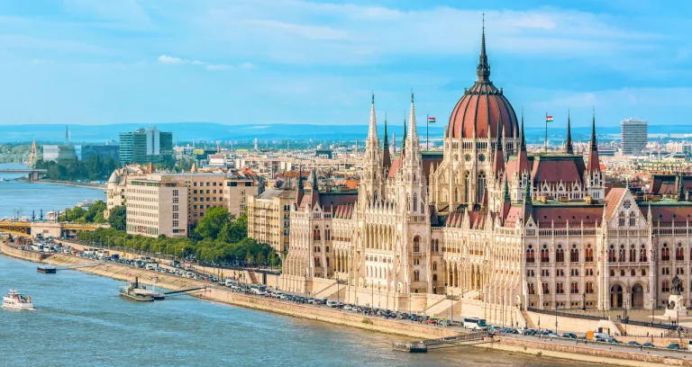 Parliament Riverside Budapest Hungary With Sightseeing Ships During Summer Day With Blue Sky Clouds