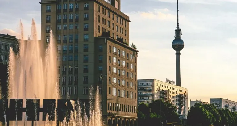 Gray Concrete Tower Near Building During Golden Hour