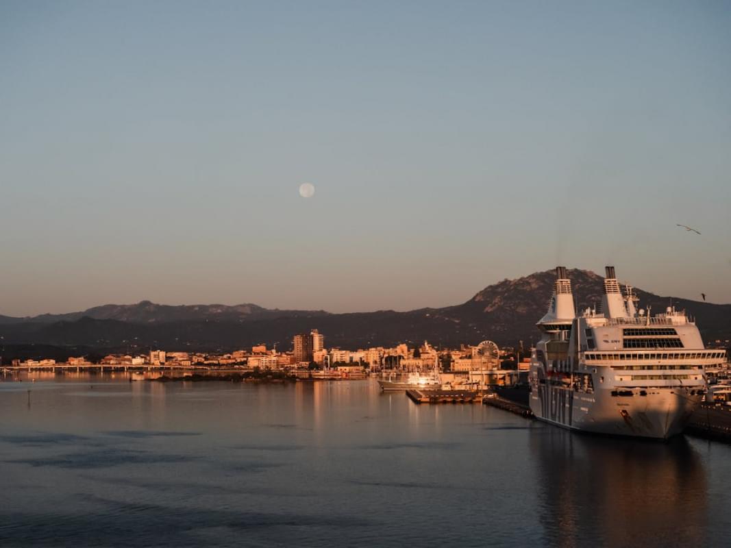 full moon in the evening sky over the harbor in olbia italy 1