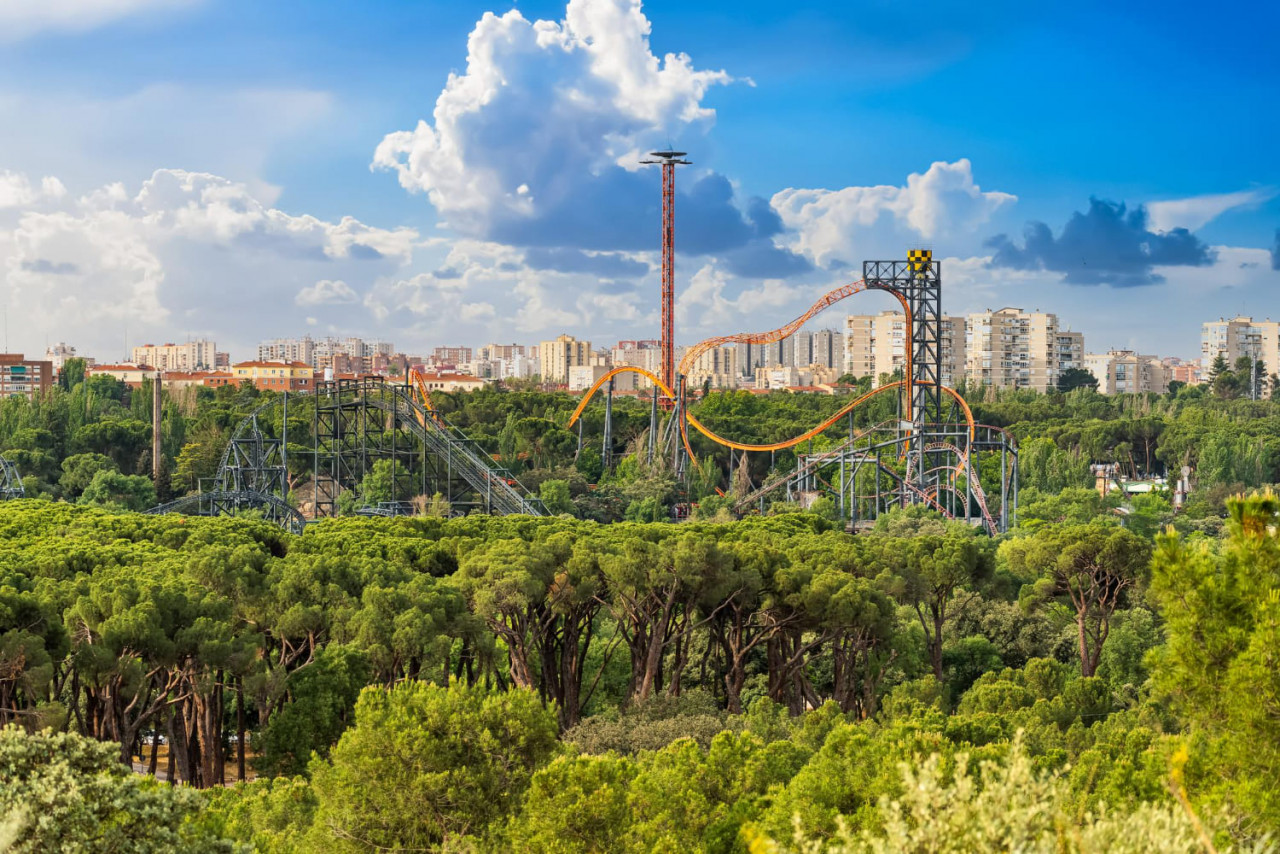 montagne russe del parco divertimenti di madrid che sbirciano sopra la vegetazione della casa de campo 1