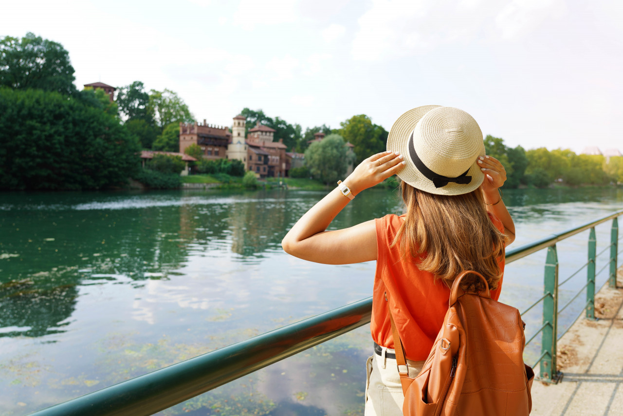 traveler girl holding her hat discovering hidden castle park young woman relaxing breathing promenade river