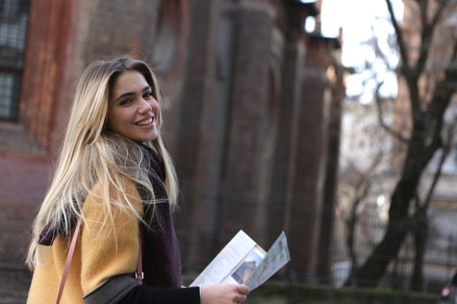 Woman in brown coat holding white printer paper