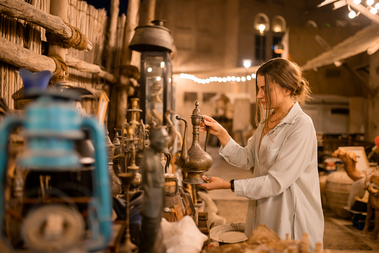 woman tourist walking arab market near al seef with crockery lamps lanterns old style